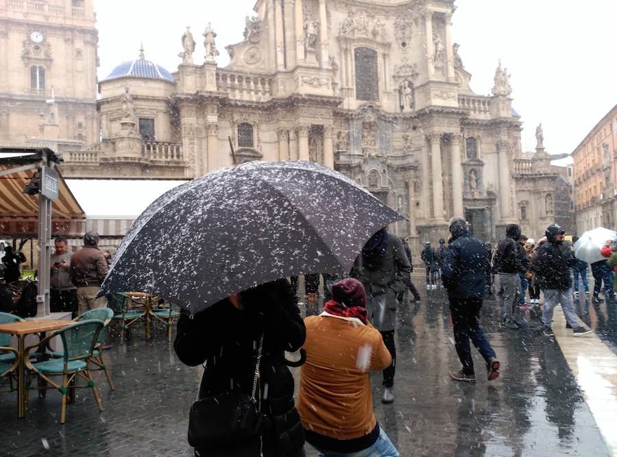 Decenas de curiosos inentan inmortalizar la Catedral nevada.