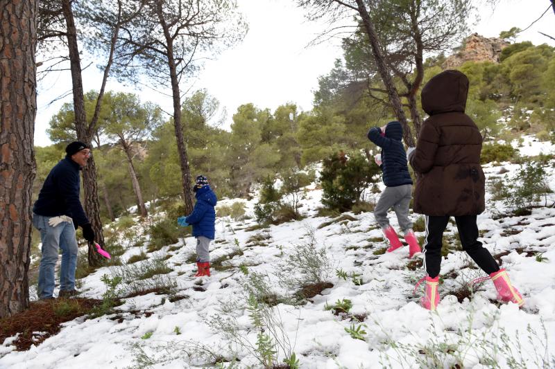 Un padre y sus tres hijas jugando con la nieve en Sierra Espuña.