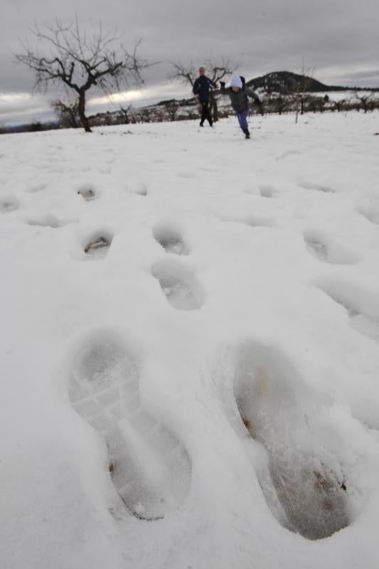 Un padre y su hijo dejan sus huellas en la nieve de Bullas.