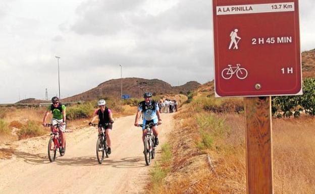 Tres cicloturistas pasan por la vía verde en Mazarrón, ayer.