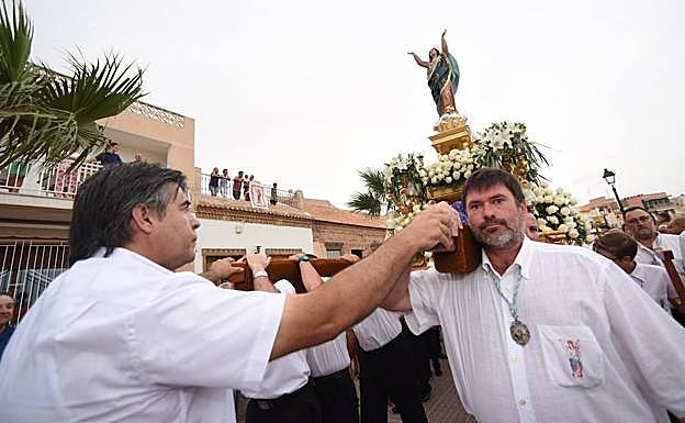El trono de la Virgen de la Asunción, a hombros de sus cofrades, por las calles de Los Alcázares.