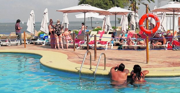 Turistas bañándose y tomando el sol, ayer, en el Hotel Roc Doblemar, recientemente reabierto en La Manga.