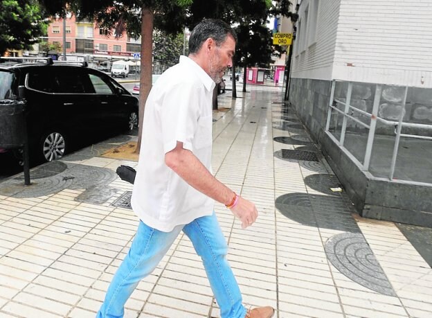 José López, con paraguas, ayer camino del juzgado. 