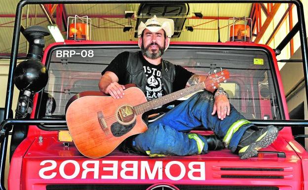 Germán Ramallo, con su guitarra, sobre el capó de un camión de bomberos. 