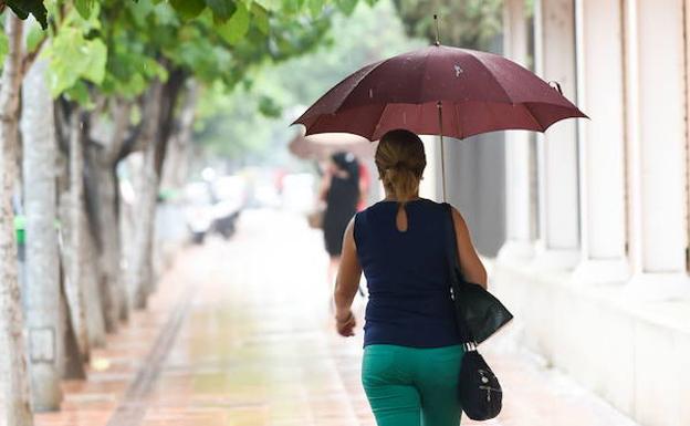 Una mujer se protege de la lluvia en Murcia. 