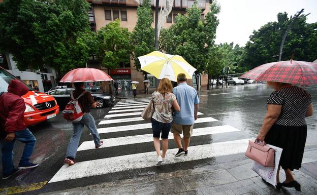 Unos viandantes se protegen de lluvia en Murcia este mes de agosto. 