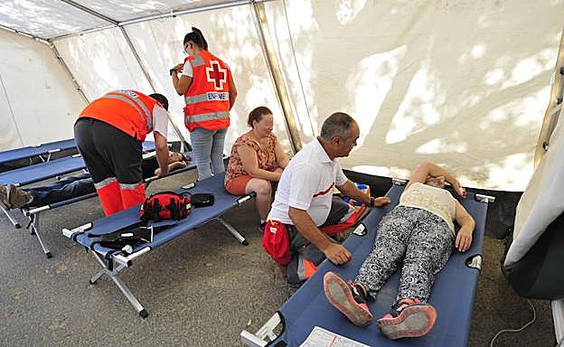 Un miembro de Cruz Roja atendiendo a una mujer.