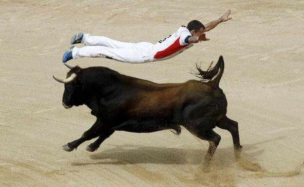 Un recortador salta sobre un toro