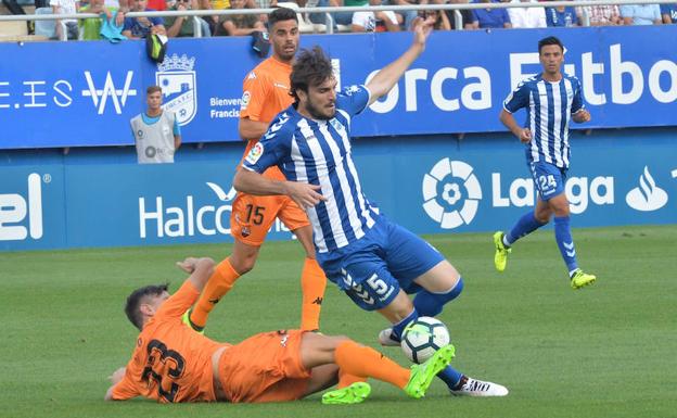 Eugeni (Lorca FC) pierde el balón ante la entrada de Tito (Reus Dep.).