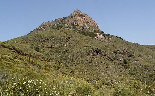El imponente Cabezo de la Fuente, en una imagen primaveral. En la esquina inferior derecha se aprecian las marcas que señalizan el sendero.