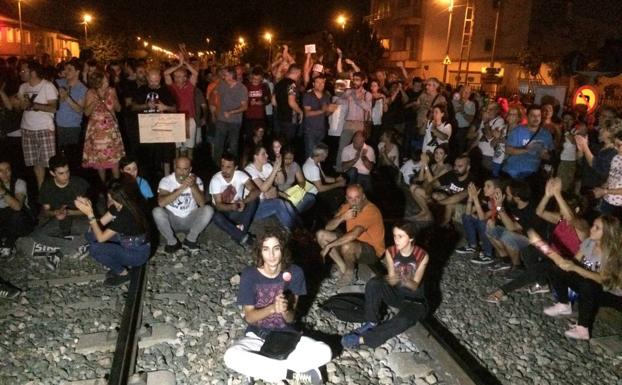 Manifestantes sentados en las vías del paso a nivel de Senda de Los Garres.