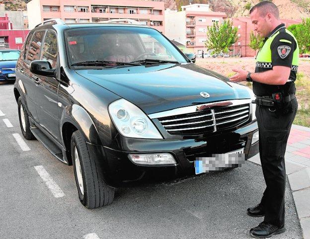 El agente Víctor Molina Moreno inspecciona un vehículo.