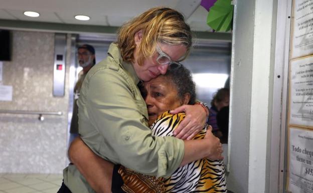 La alcaldesa de San Juan, Carmen Yulín Cruz (i), abraza a una mujer.