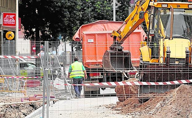 Un operario, ayer junto a un camión y una excavadora, en las obras de remodelación de la calle Licenciado Cascales, en el casco histórico de Cartagena.