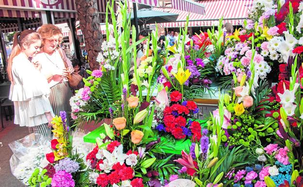 Ramos y centros preparados en la plaza de las Flores para el día de Todos los Santos.