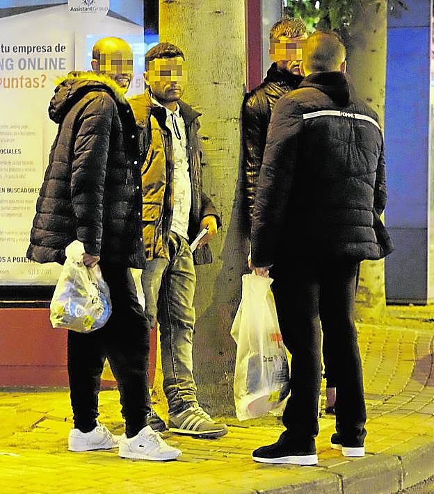 Varios de los 'sin papeles' llegados ayer, buscando refugio en la calle, tras salir de Comisaría con bolsas de la Cruz Roja en las manos.
