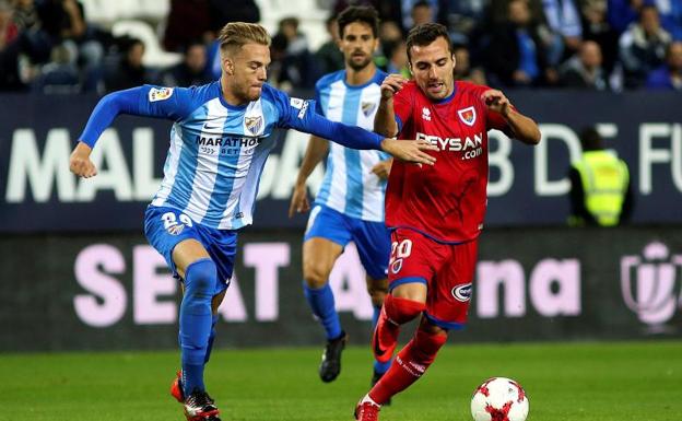 Pino, defensa del Málaga, disputa un balón con Valcarce, centrocampista del Numancia. 