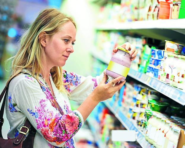 Una mujer revisa el etiquetado de un producto en un supermercado. 