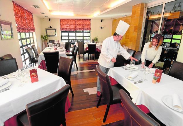 Juan Mari y Yolanda preparan la sala del restaurante.