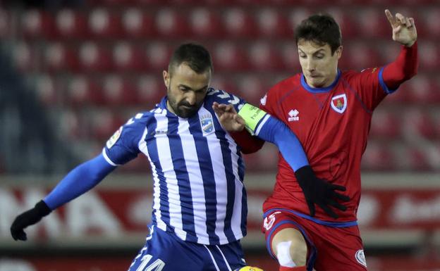 Bustos puja por el control del balón con un jugador del Numancia.