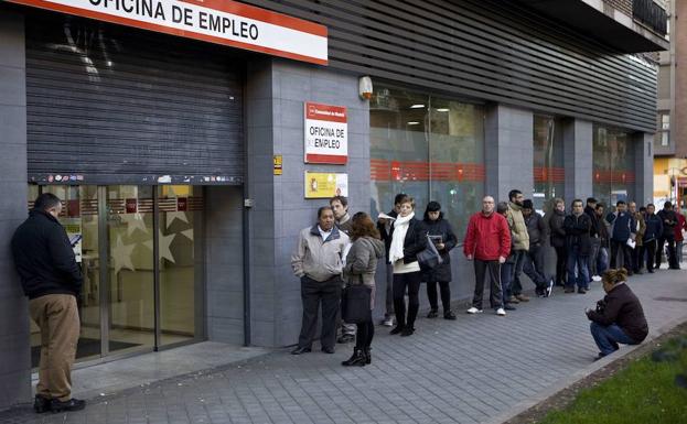 Numerosas personas hacen cola en una oficina de empleo de Madrid.