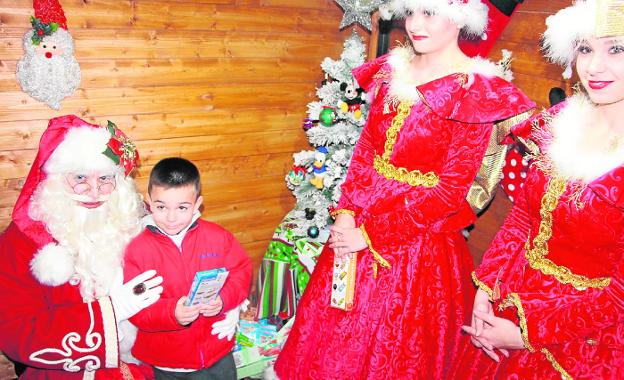 Papá Noel recibe a un niño en la Casa de la Navidad instalada en San Pedro del Pinatar.