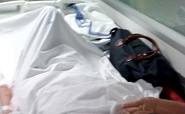 Una paciente en un pasillo de Urgencias, ayer, junto a un cartel en el que se señala que debe estar en 'aislamiento de contacto'.