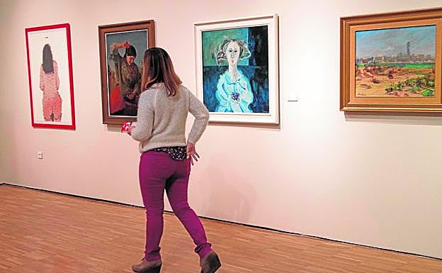 Una mujer observa varias de las obras de pintores murcianos expuestas en el Mubam, ayer.