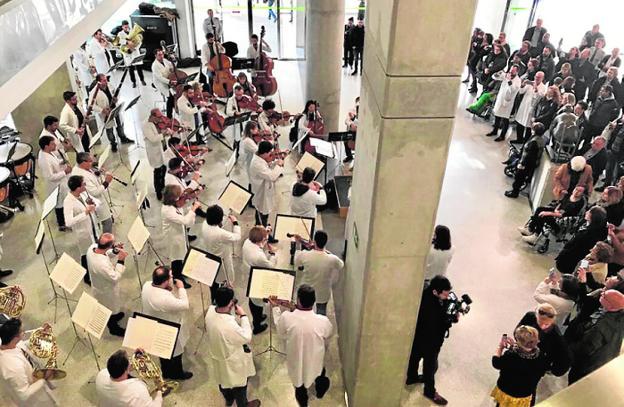 Los músicos de la OSRM, ataviados con batas blancas, tocan en el vestíbulo del Reina Sofía en Murcia.