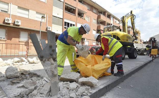 Dos operarios retiran piedras en El Palmar. 