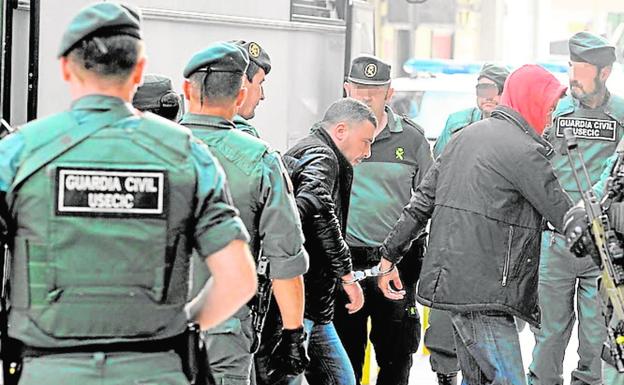 Guardias civiles trasladando a dos de los presuntos integrantes de la 'banda de los encapuchados' en abril de 2016.