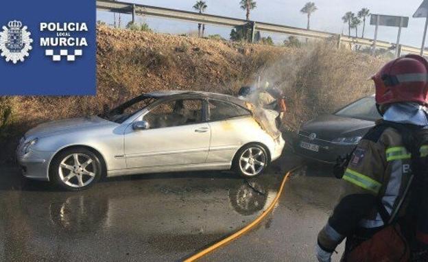Un bombero observa el coche afectado por las llamas.