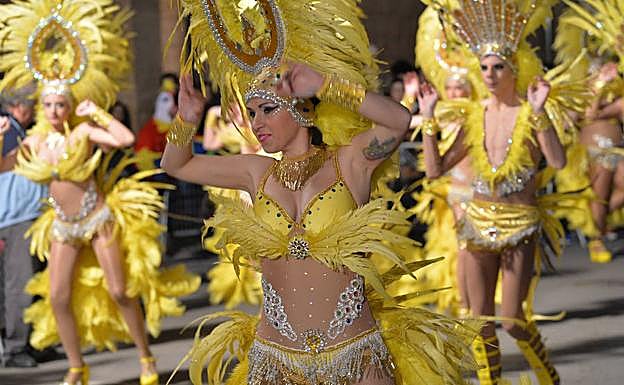 Varias carnavaleras de una peña exhiben sus coloridos trajes al ritmo de la música. 