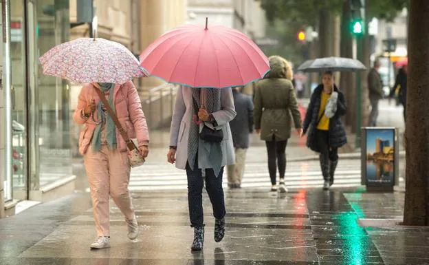 Dos jóvenes pasean bajo la lluvia en Murcia, en una foto de archivo. 