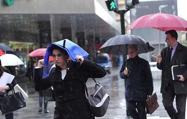 Unos murcianos se protegen de la lluvia / Foto de archivo