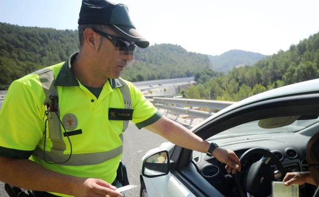 Un agente de la Guardia Civil multa a un conductor en un control de tráfico en el Puerto de la Cadena de Murcia. 