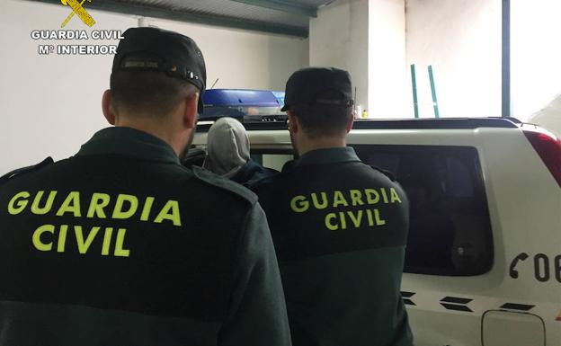 Dos agentes escoltan a uno de los detenidos. 