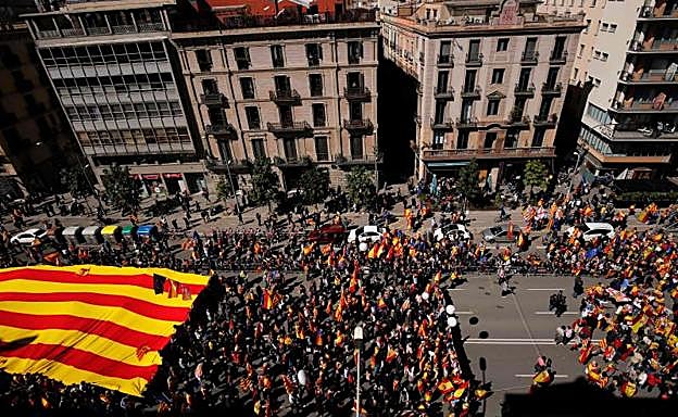 Miles de personas sostienen la bandera catalana.