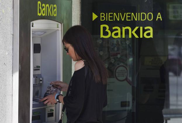 Una mujer usa un cajero de Bankia. 