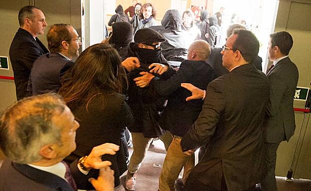 Forcejeo entre uno de los enmascarados y los asistentes.