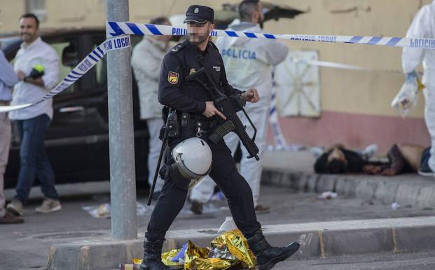 Un policía custodia la escena del crimen de Las Seiscientas, en Cartagena, en el que murieron dos personas. 