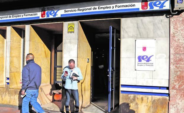 Un hombre consulta su teléfono a las puertas de la oficina del SEF en Ronda Norte de Murcia