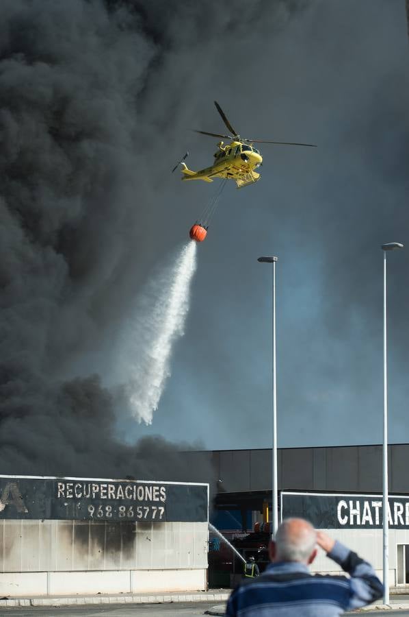 Los bomberos trabajan en la extinción de un incendio en una empresa de reciclaje de residuos en Santomera que ha originado una gran columna de humo a primera hora de la tarde, alrededor de las 16.30 horas de este miércoles.