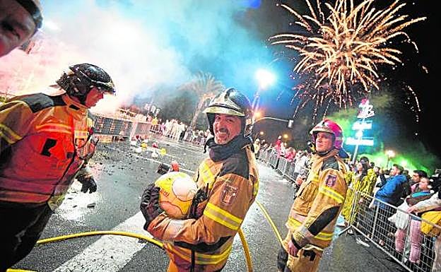 Efectivos del Cuerpo de Bomberos, durante la quema de la sardina en la plaza Martínez Tornel, abarrotada de gente. 