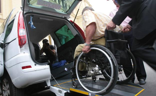Un hombre en silla de ruedas es ayudado para acceder a un 'eurotaxi', en una imagen de archivo.
