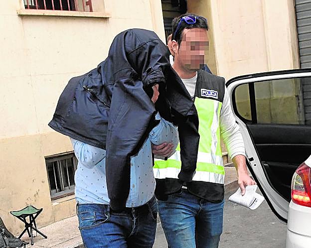 El presunto cabecilla de la trama española, Miguel T. M., escoltado por un policía.