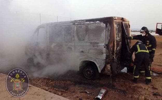 Los bomberos apagan el fuego del interior de la furgoneta. 