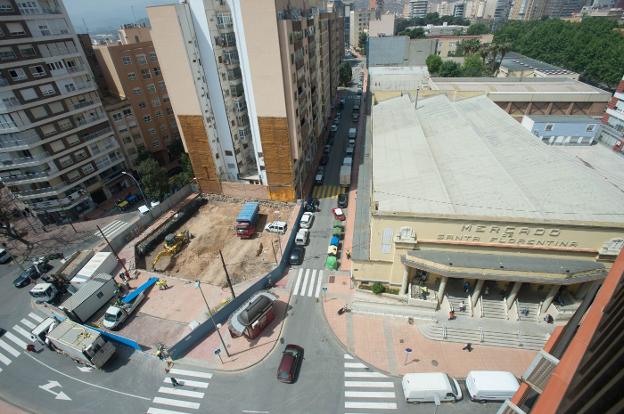Un obrero trabaja junto a la parcela recién vallada que albergará un nuevo edificio de viviendas en la calle Juan Fernández, junto al Mercado de Santa Florentina.