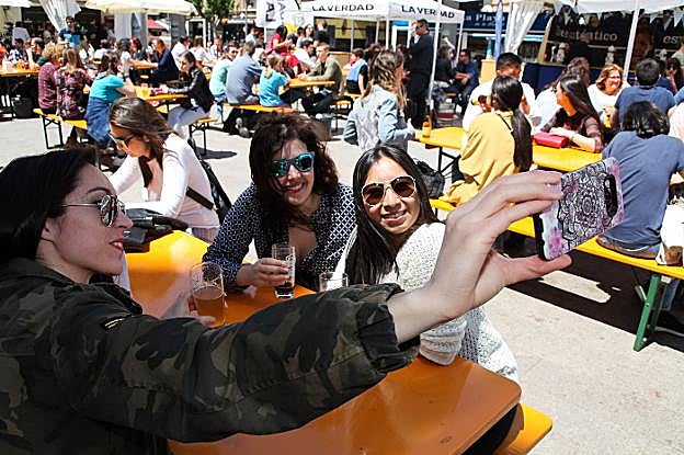 Un grupo de jóvenes toma un selfi con sus vasos de cerveza, ayer, en la plaza de la Universidad.