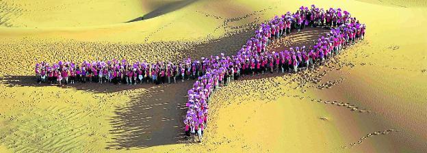 Participantes en el rally Roses des Sables de 2012 forman un lazo en solidaridad con las enfermas de cáncer de mama en el desierto de Marruecos. 